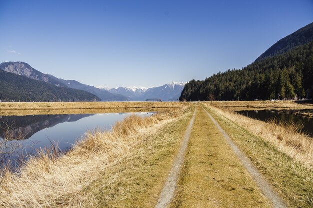 Paisaje de Wigeon Slough rodeado de colinas bajo la luz del sol en la Columbia Británica, Canadá