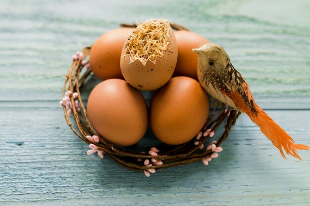 Pájaro de juguete cerca de huevos