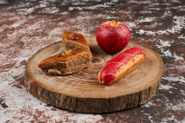 Foto gratuita pakhlava y eclair sobre una tabla de madera.