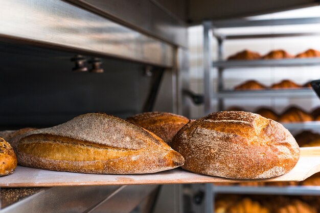 Pala de madera con pan recién horneado del horno.