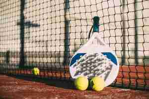 Foto gratuita pala de padel que descansa sobre la red