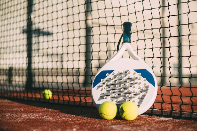 Pala de padel que descansa sobre la red