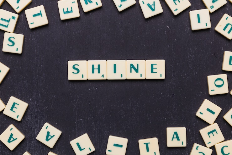 Foto gratuito palabra brillo hecha de letras scrabble sobre fondo negro