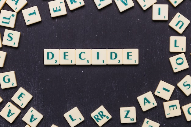 Foto gratuita la palabra decide en letras scrabble sobre fondo negro