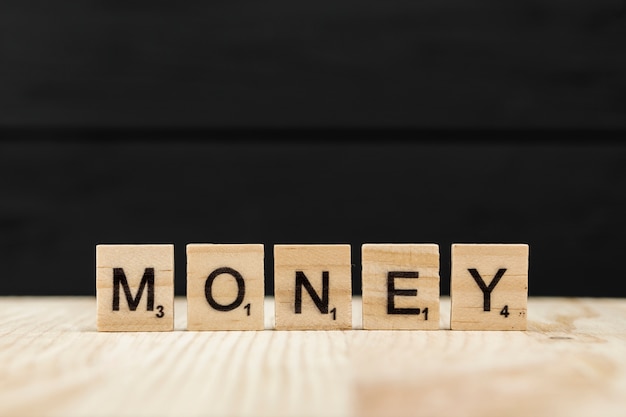 La palabra dinero escrito con letras de madera.