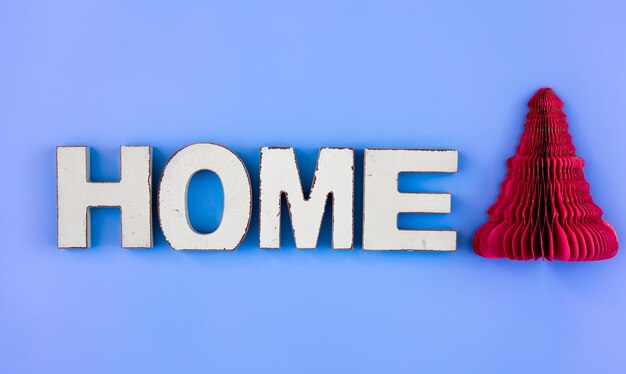 La palabra hogar en letras de madera sobre un fondo azul