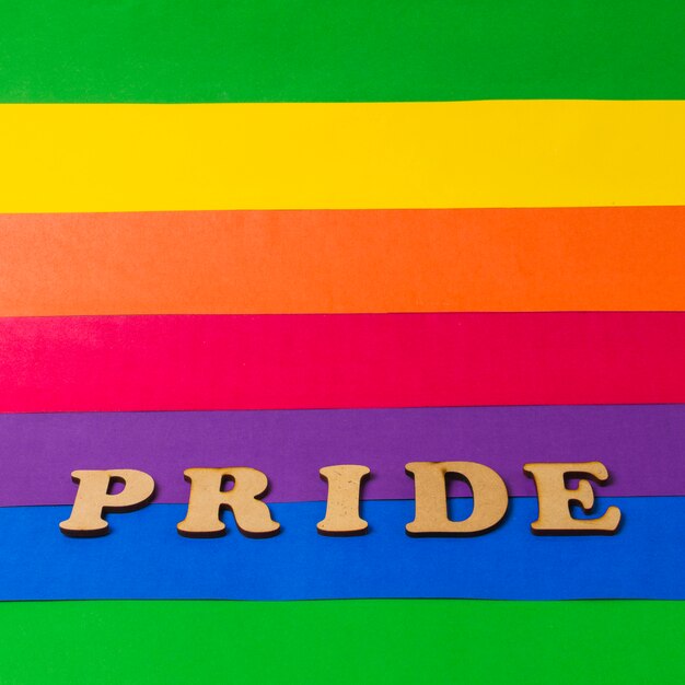Palabra de madera del orgullo en la bandera de colores LGBT