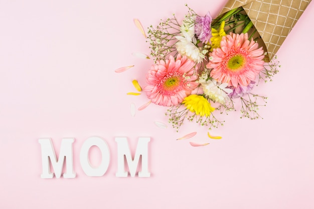 Foto gratuita palabra de mamá cerca de ramo de flores frescas en envoltura