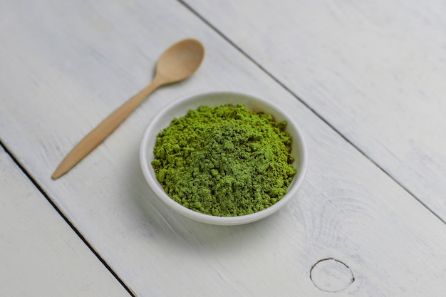 Palabra matcha hecha de té verde matcha en polvo y cuchara de bambú en blanco. Copiar