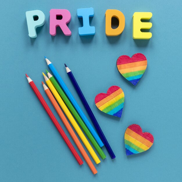 Palabra de orgullo con lápices de colores y forma de corazón