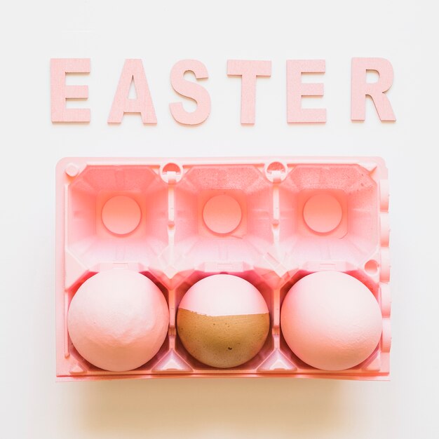 Palabra de Pascua y huevos en estante rosa