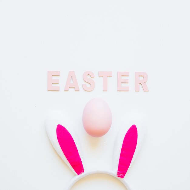 Palabra de Pascua con orejas de conejo y huevo