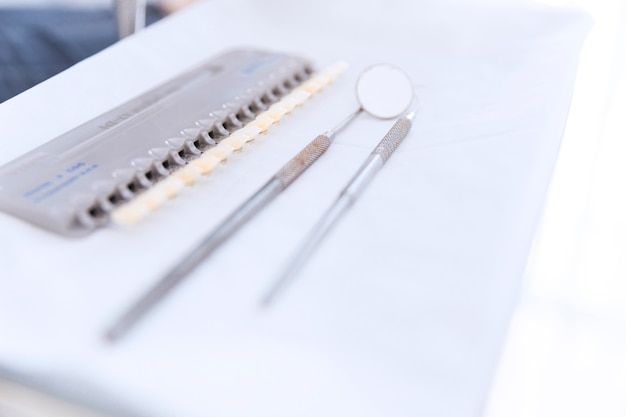 Paleta de tonos de dientes con espejo dental y sonda en el escritorio