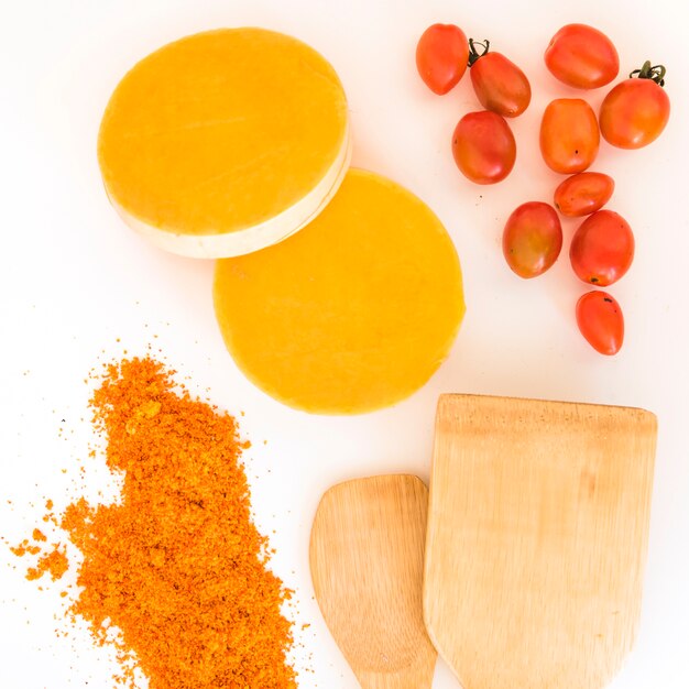 Paletas junto a los tomates, pimientos y frutas naranjas.