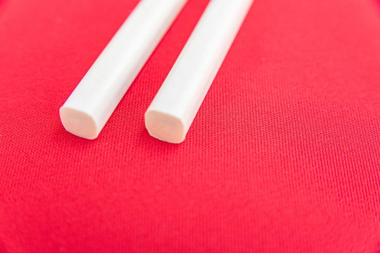 Foto gratuito palillos blancos sobre la mesa roja