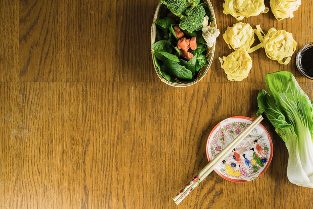 Palillos cerca de fideos y verduras