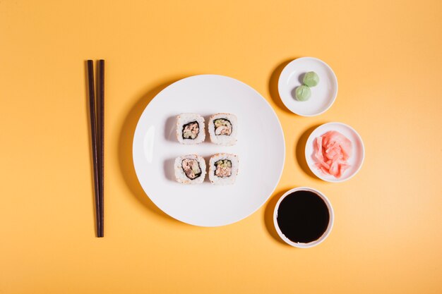 Palillos y condimentos cerca del sushi