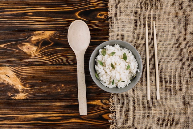 Foto gratuita palillos y cuchara cerca de arroz hervido