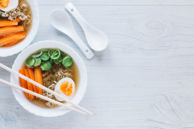 Palillos y cucharas cerca de fideos soupe