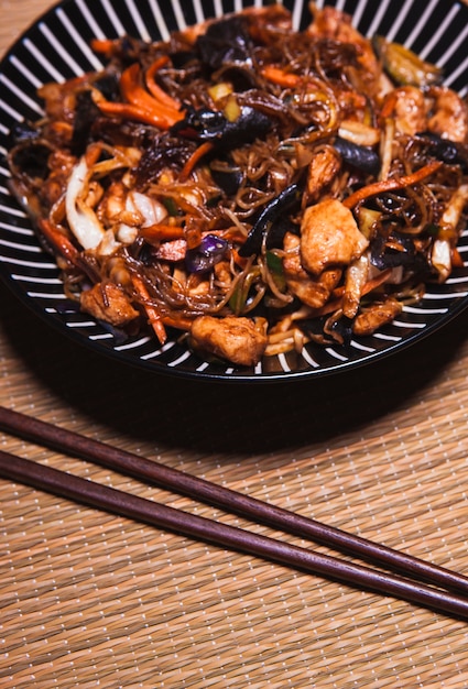 Palillos de primer plano y comida china en trapo