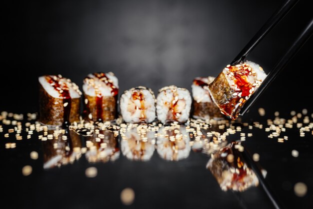 Palillos con rollo Uguri hecho de Nori, arroz en escabeche, anguila / perca Unagi