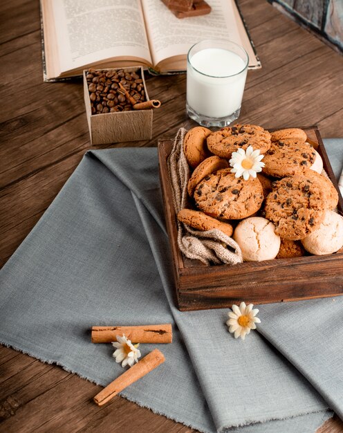 Palitos de canela y una caja de galletas sobre un mantel azul