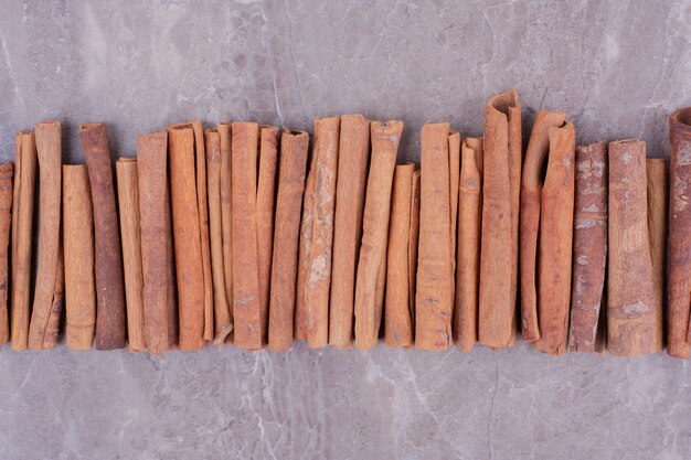 Palitos de canela en una fila sobre la superficie de la piedra