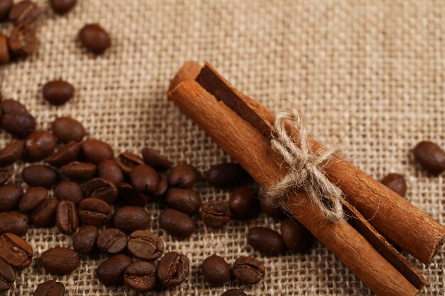 Palitos de canela y granos de café en un pedazo de arpillera.