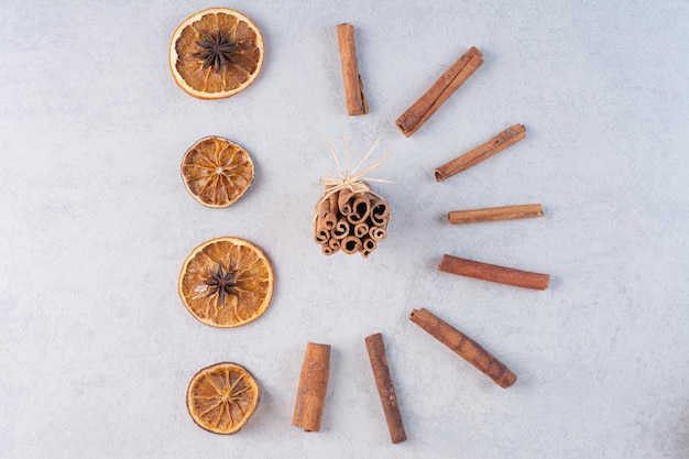 Palitos de canela con rodajas de naranja secas en el suelo.