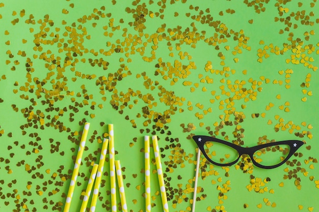 Foto gratuita palitos dorados con confeti dorado y unas gafas