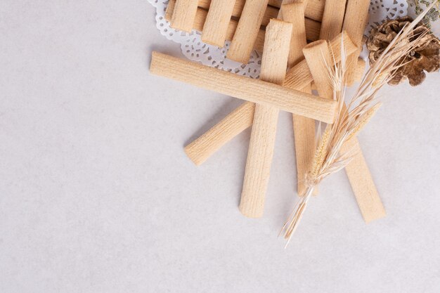 Palitos de galleta con piña sobre superficie blanca