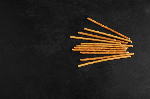 Palitos de galleta sobre un fondo negro.