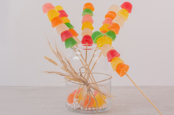 Foto gratuito palitos de mermeladas de colores en frasco de vidrio.