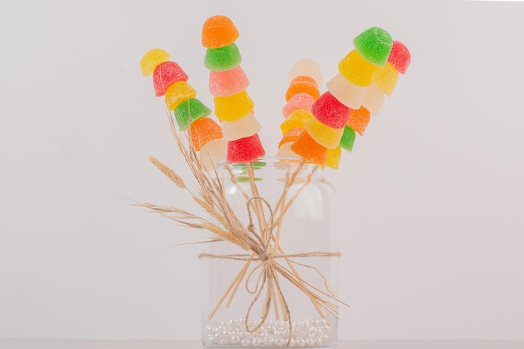 Foto gratuito palitos de mermeladas de colores en frasco de vidrio.