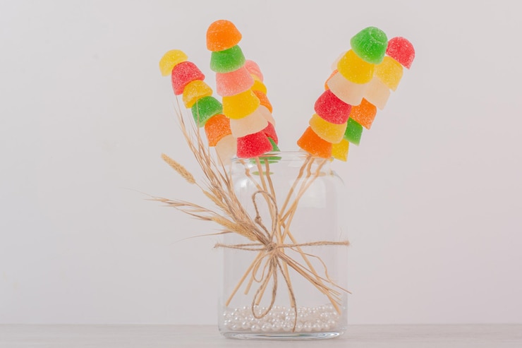 Foto gratuito palitos de mermeladas de colores en frasco de vidrio.