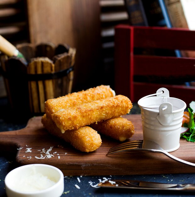 Palitos de mozzarella en la mesa de corte