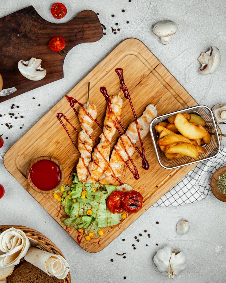 Foto gratuito palitos de pollo asado con papas fritas