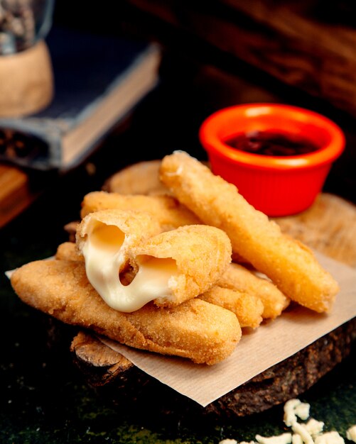 Palitos de queso rebozados en un cáñamo de madera