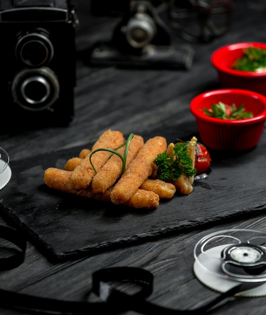 Foto gratuita palitos de queso sobre una plancha de madera