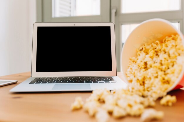 Foto gratuita palomitas de maíz cerca de la computadora portátil