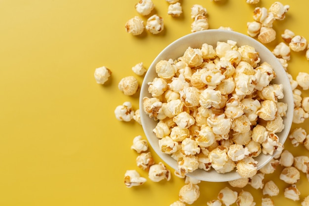 Palomitas de maíz dulce sobre fondo amarillo