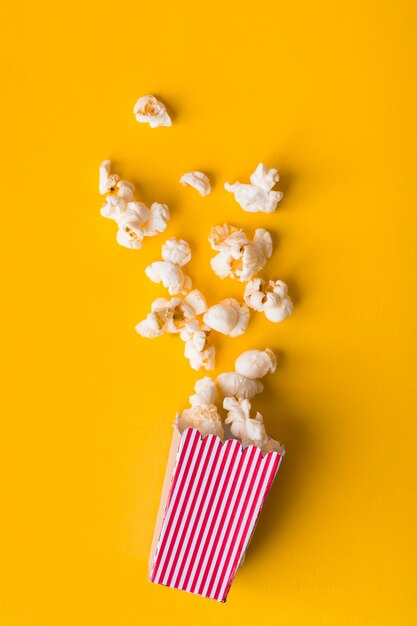 Palomitas de maíz planas sobre fondo amarillo