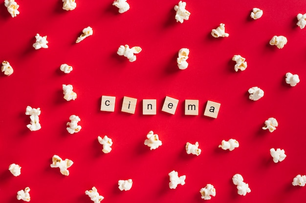 Palomitas de maíz planas sobre fondo rojo con letras de cine