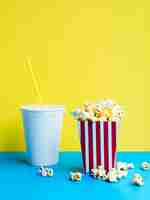 Foto gratuita palomitas de maíz con refresco en colores de fondo