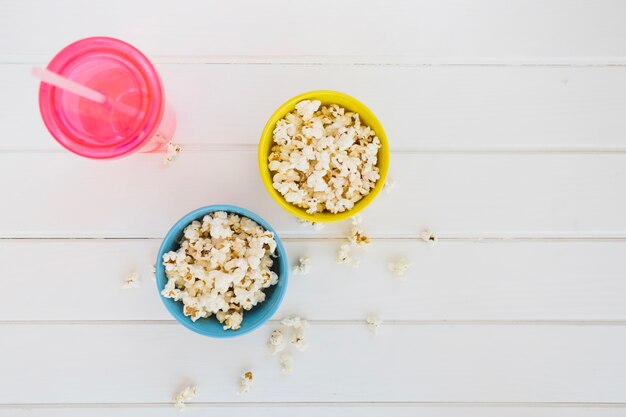 Palomitas de maíz en tazas y bebida refrescante