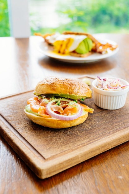 Pan de bagel con salmón ahumado y verdura.