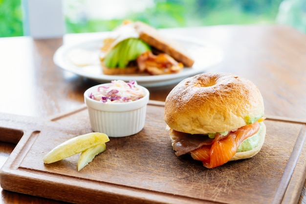 Pan de bagel con salmón ahumado y verdura.