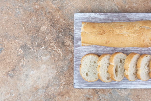 Pan baguette fresco sobre tabla de madera