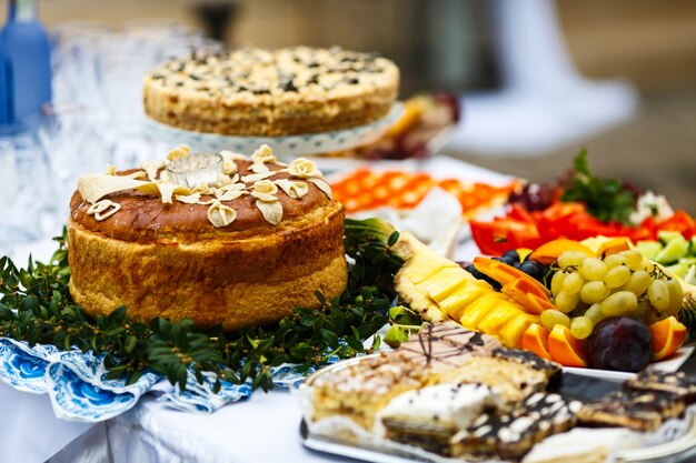 Pan de la boda servido en plato con vegetación se encuentra entre platos