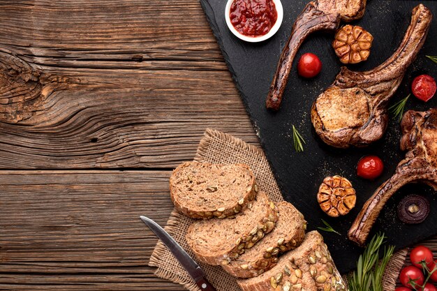 Pan y carne cocida sobre tabla de madera